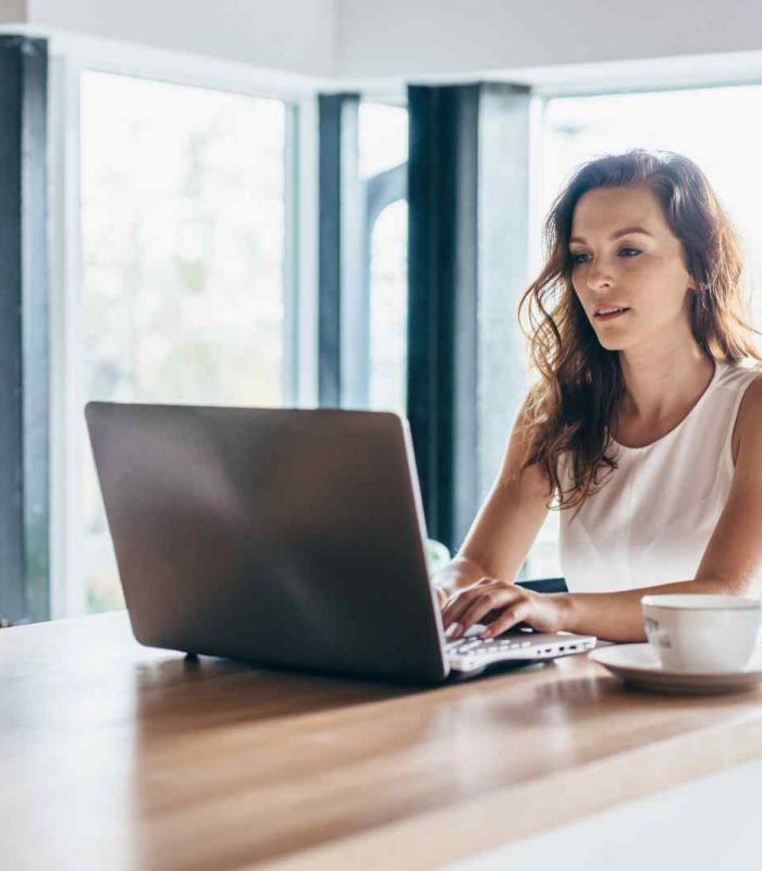 Woman using laptop while sitting at home.