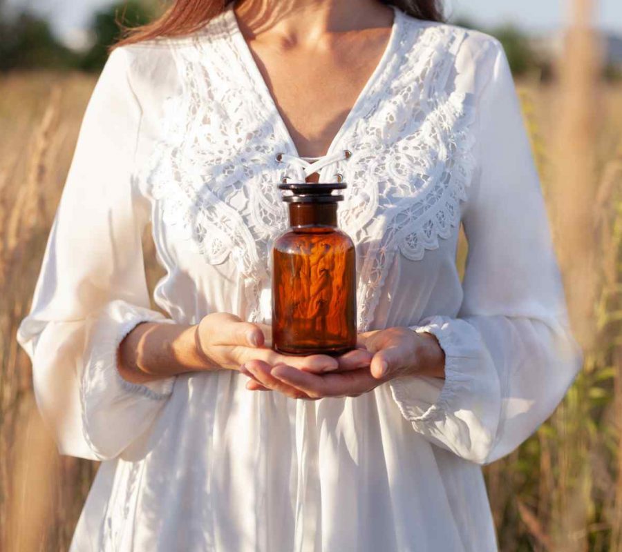 Woman,Picking,Herbs,Against,The,Backdrop,Of,A,Meadow.,Holding